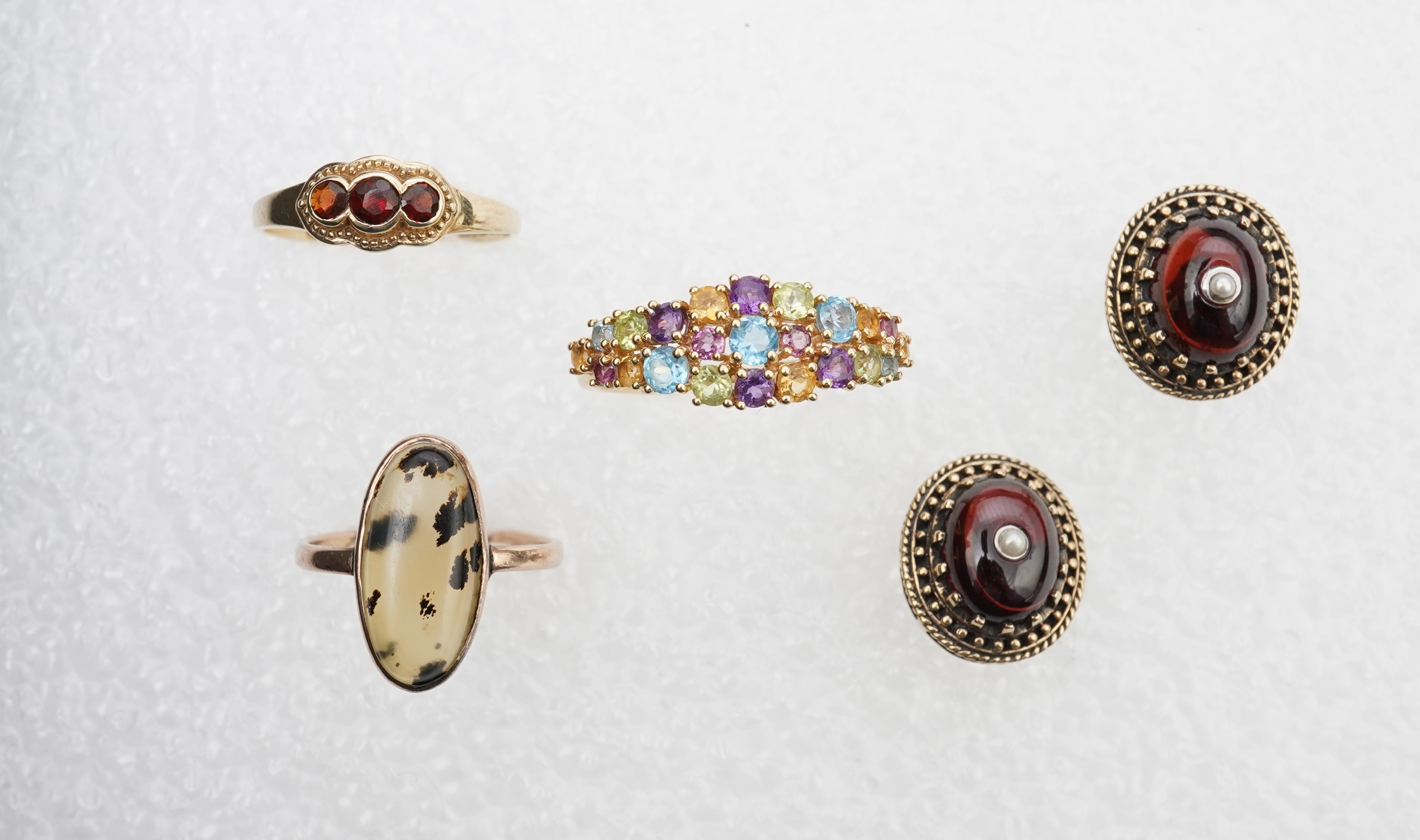 A modern 18ct gold and multi gem set cluster ring, size P, together with two 9ct rings including moss agate and a pair of 9ct gold and seed pearl set cabochon garnet ear studs.